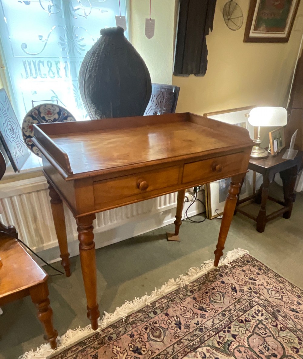A Victorian satin birch writing desk featuring a three-quarter gallery top, two frieze drawers with turned wooden knobs, and four turned legs. View VIII
