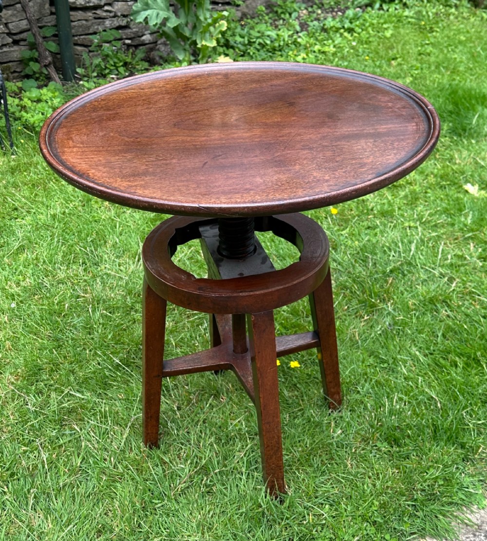 An antique round mahogany wine table with a moulded top and a threaded height-adjusting central screw resting on four legs. View III