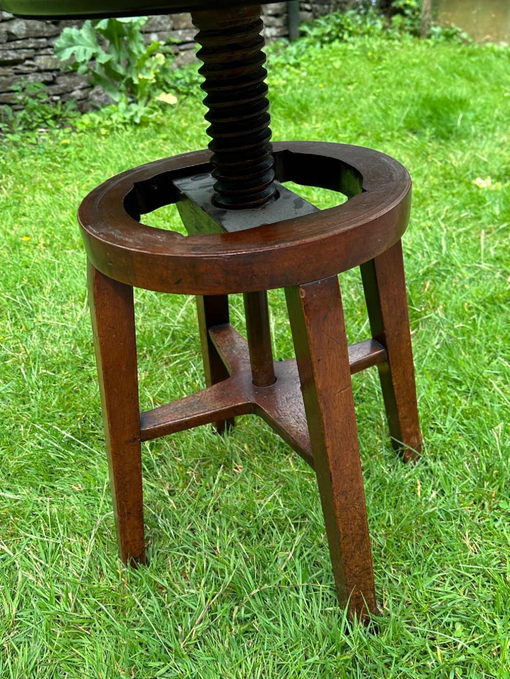 An antique round mahogany wine table with a moulded top and a threaded height-adjusting central screw resting on four legs. View IV