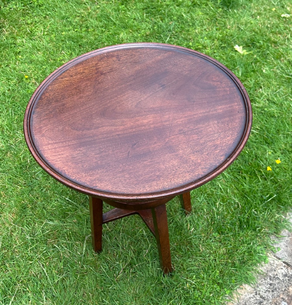 An antique round mahogany wine table with a moulded top and a threaded height-adjusting central screw resting on four legs. View V