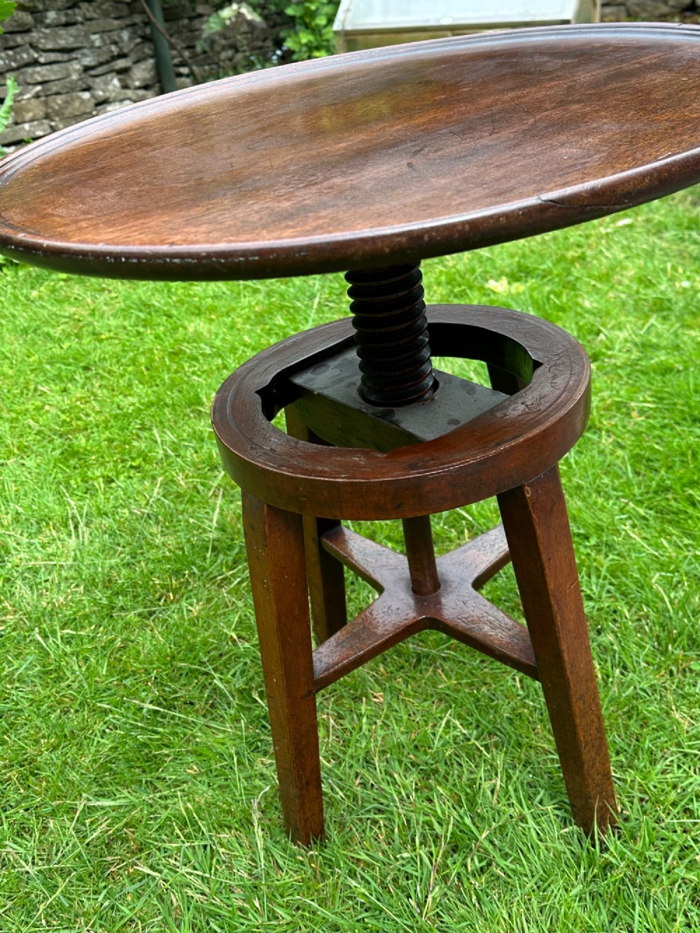 An antique round mahogany wine table with a moulded top and a threaded height-adjusting central screw resting on four legs. View VII