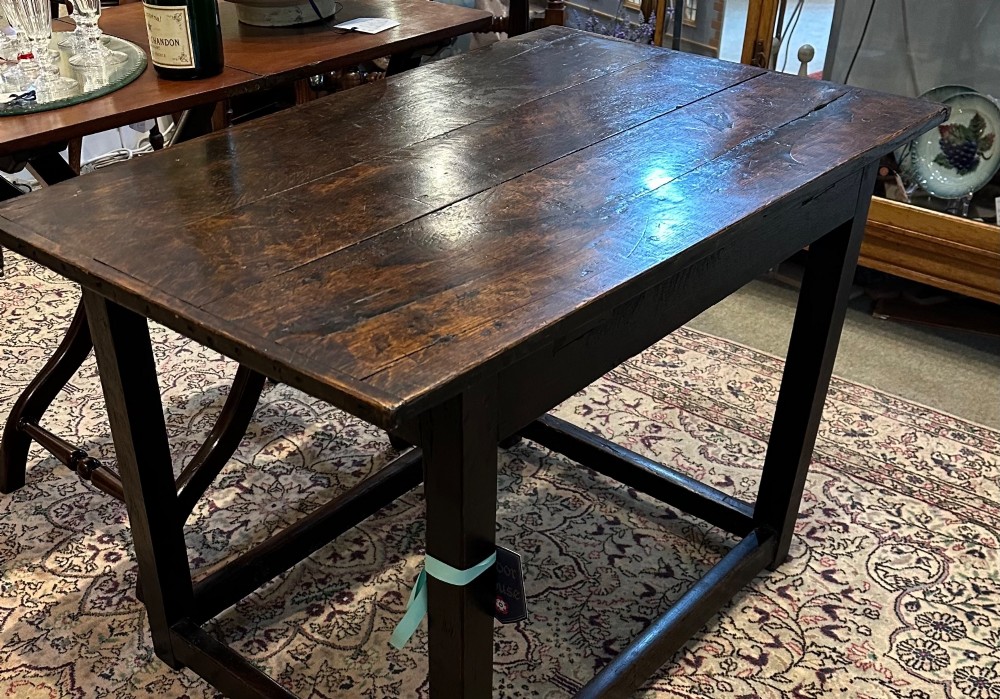 An antique dark brown oak table featuring a plank top surface, square legs, and low box stretchers. View VII