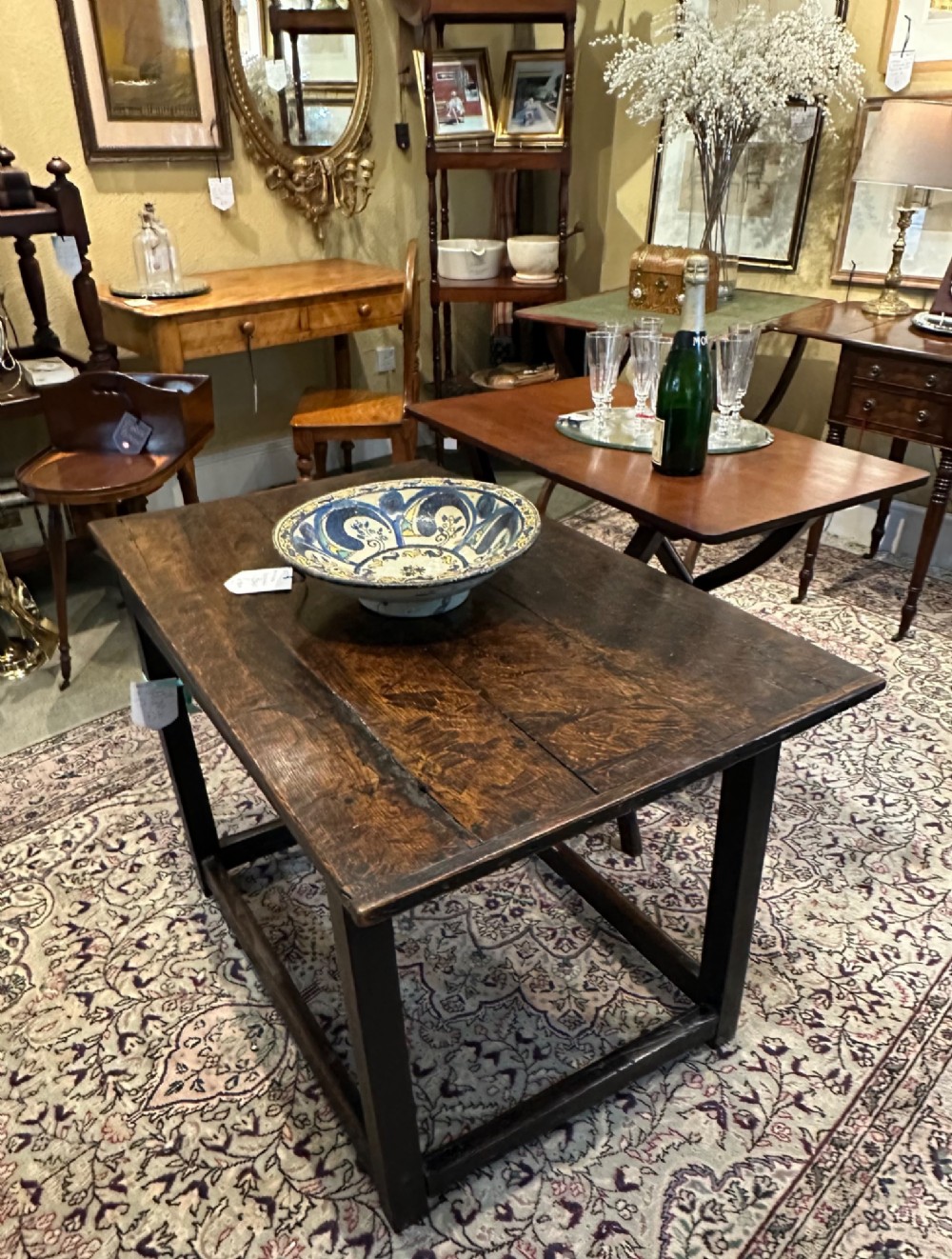 An antique dark brown oak table featuring a plank top surface, square legs, and low box stretchers. View VIII