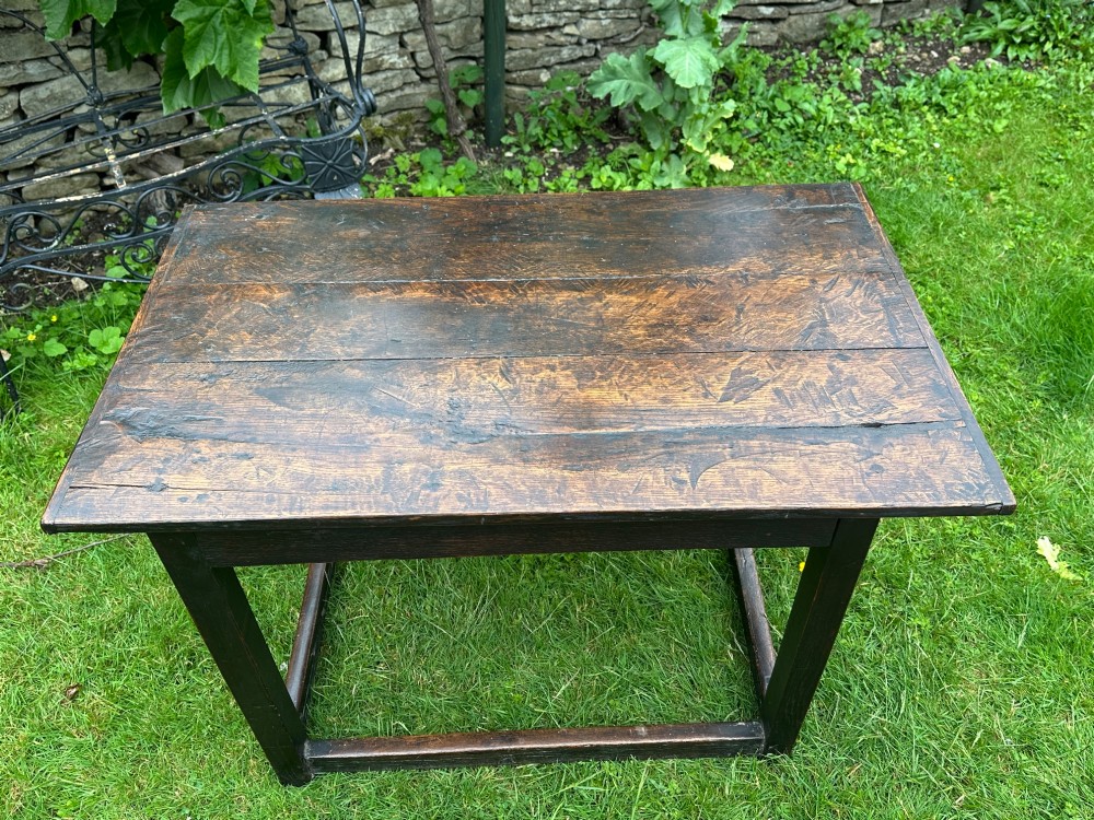 An antique dark brown oak table featuring a plank top surface, square legs, and low box stretchers. View IX