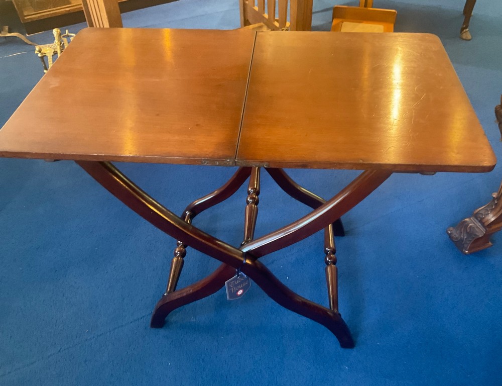 A Victorian mahogany coaching table featuring a hinged rectangular folding top supported by an X-frame base with turned stretchers. View VI