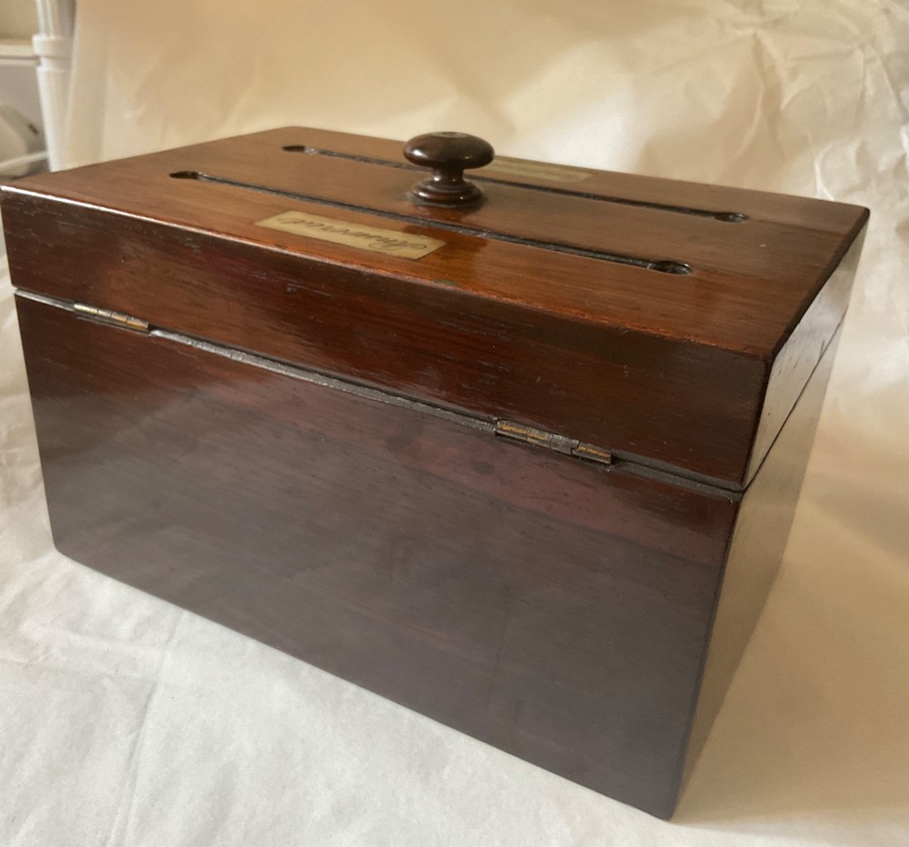 A dark mahogany 19th-century letter box featuring two top slots labelled Answered and Unanswered, a turned central knob, and a front keyhole with an inserted key. View VIII