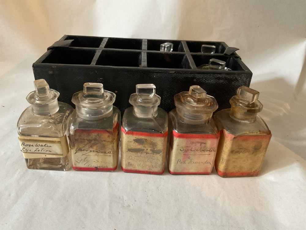 A square Victorian tan leather apothecary case featuring a fold-over front flap secured by a central metal latch. View VI