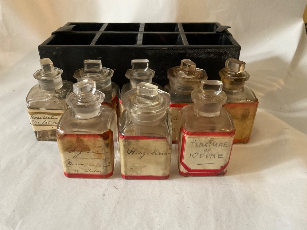A square Victorian tan leather apothecary case featuring a fold-over front flap secured by a central metal latch. View VII