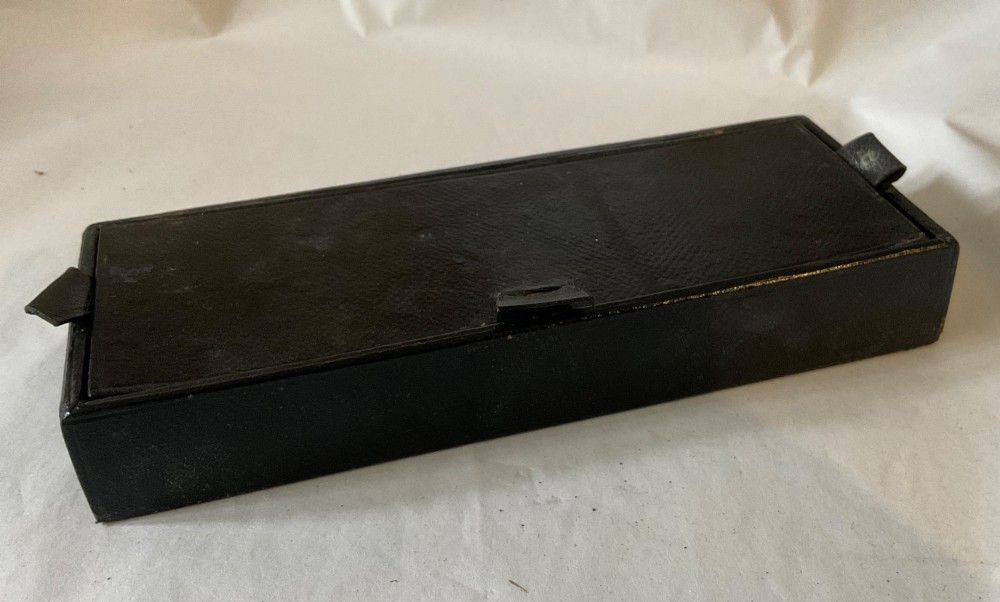 A square Victorian tan leather apothecary case featuring a fold-over front flap secured by a central metal latch. View VIII