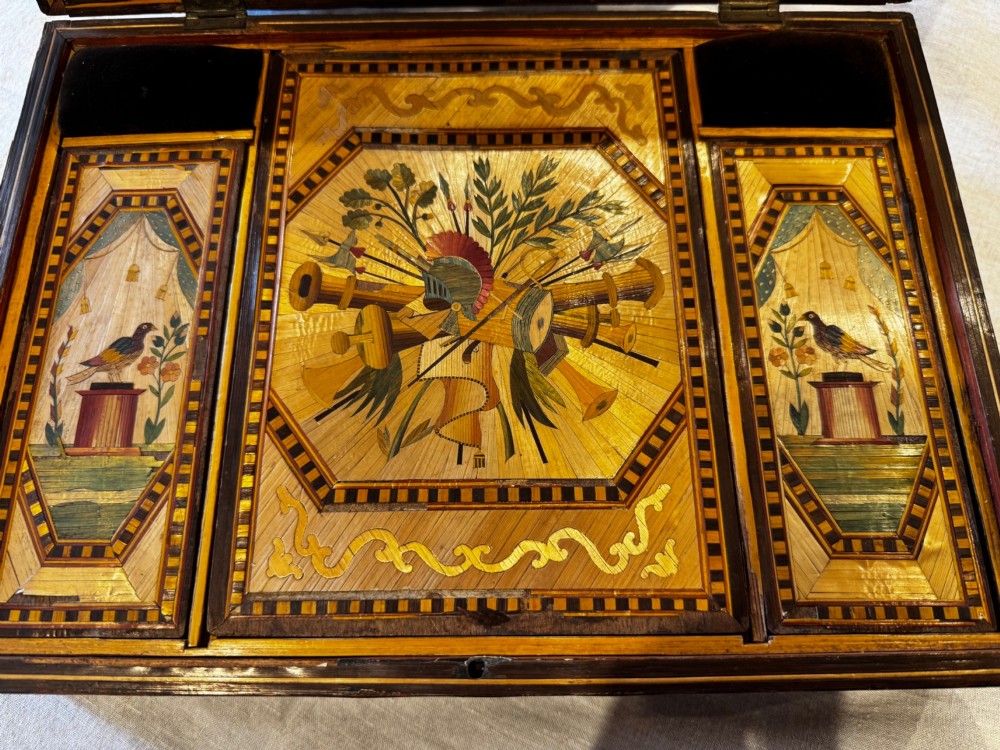 An antique rectangular wooden box embellished with straw marquetry forming a central floral basket surrounded by intricate decorative borders in golden yellow and brown shades. View III