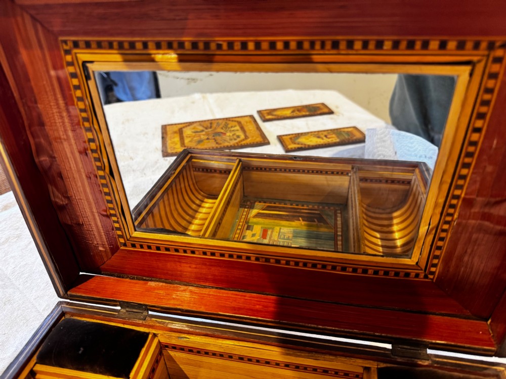 An antique rectangular wooden box embellished with straw marquetry forming a central floral basket surrounded by intricate decorative borders in golden yellow and brown shades. View V