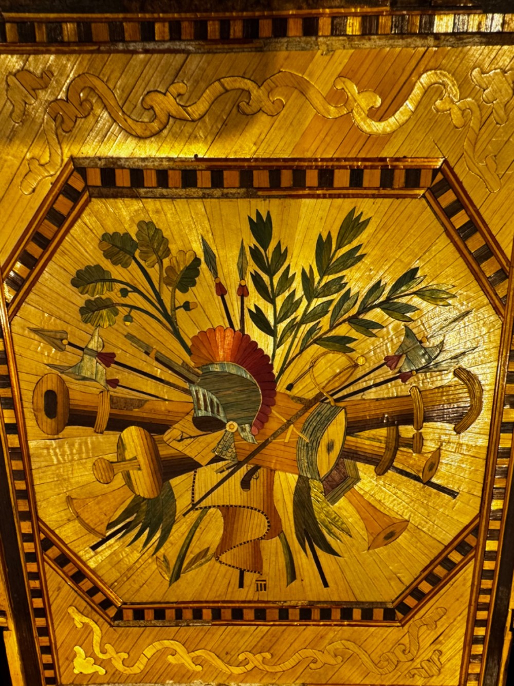 An antique rectangular wooden box embellished with straw marquetry forming a central floral basket surrounded by intricate decorative borders in golden yellow and brown shades. View IX