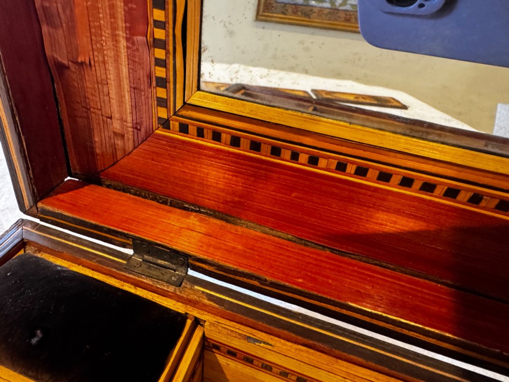 An antique rectangular wooden box embellished with straw marquetry forming a central floral basket surrounded by intricate decorative borders in golden yellow and brown shades. View XI