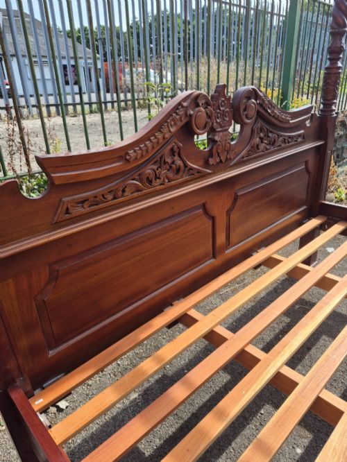 fig 3. A super king size four-poster bed frame crafted from dark carved wood featuring spiral twisted posts and a scrolled headboard crest.