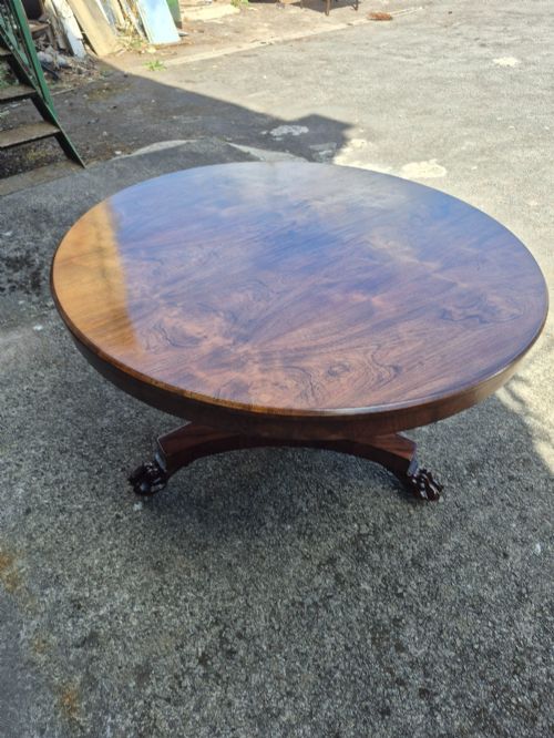 fig 3. A circular Regency rosewood breakfast table featuring a figured veneer top resting on a central pedestal column with a triform base and carved feet.