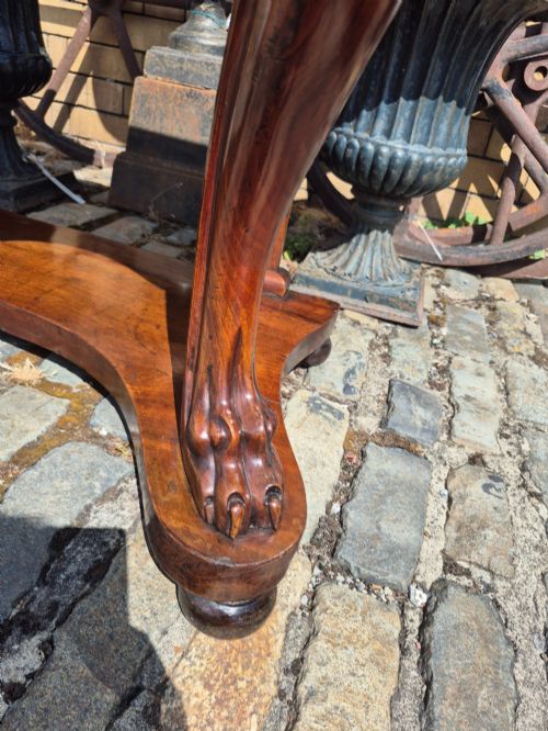 fig 3. An early Victorian mahogany console table with a shaped serpentine top, carved cabriole front legs, and an undertier shelf resting on a plinth base.