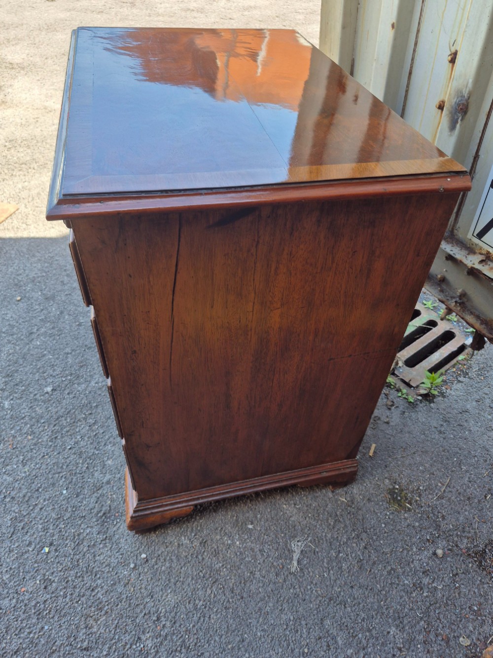 An 18th-century Georgian walnut bachelors chest featuring a brushing slide, four graduated drawers with brass handles, and bracket feet. View III