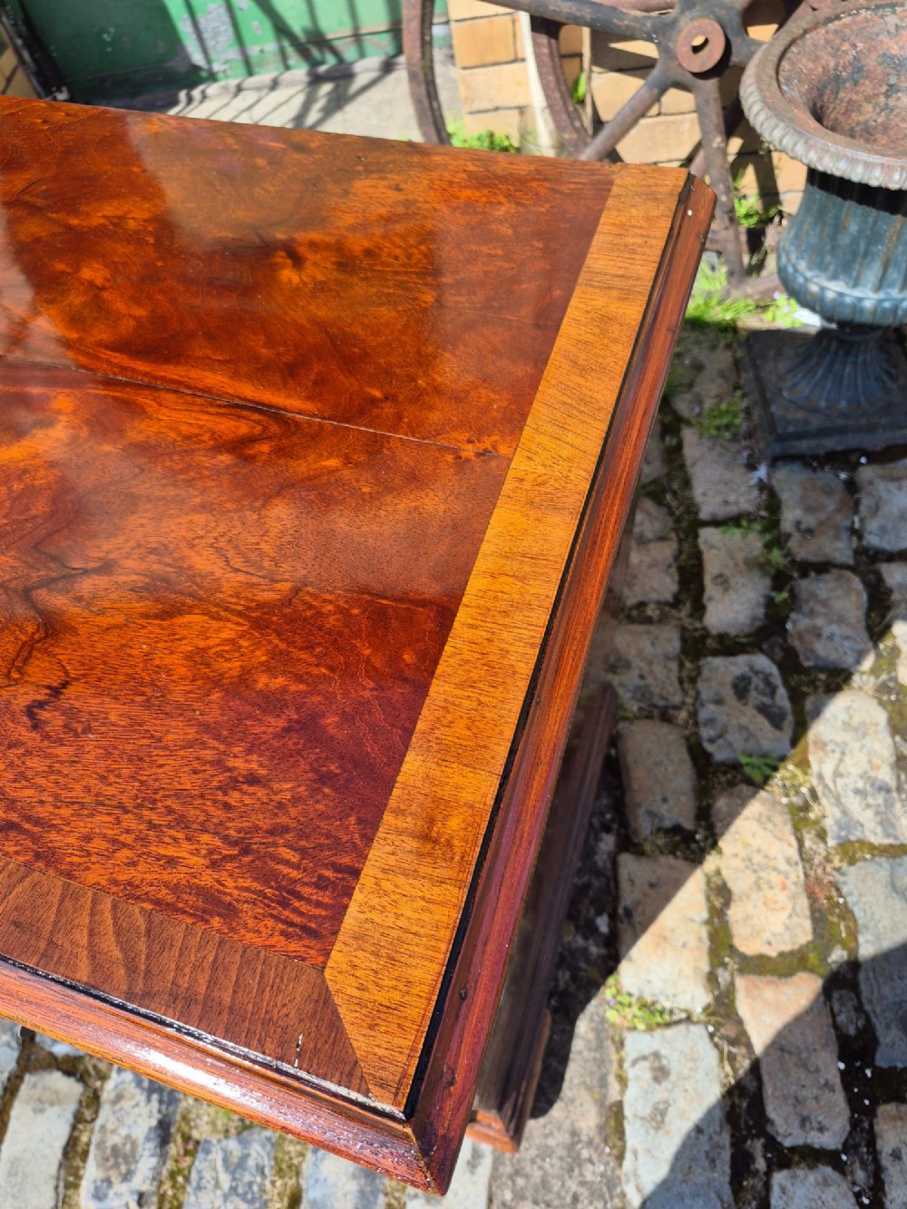 An 18th-century Georgian walnut bachelors chest featuring a brushing slide, four graduated drawers with brass handles, and bracket feet. View V