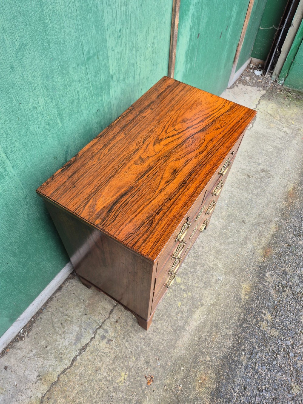 A small rosewood chest of drawers featuring brass handles, bracket feet, and a pull-out brushing slide. View III