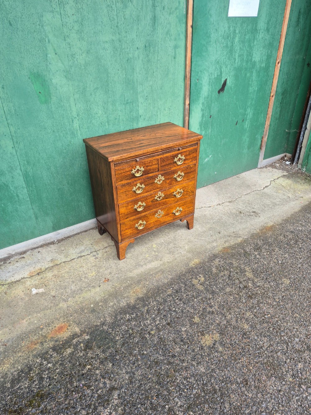 A small rosewood chest of drawers featuring brass handles, bracket feet, and a pull-out brushing slide. View VIII
