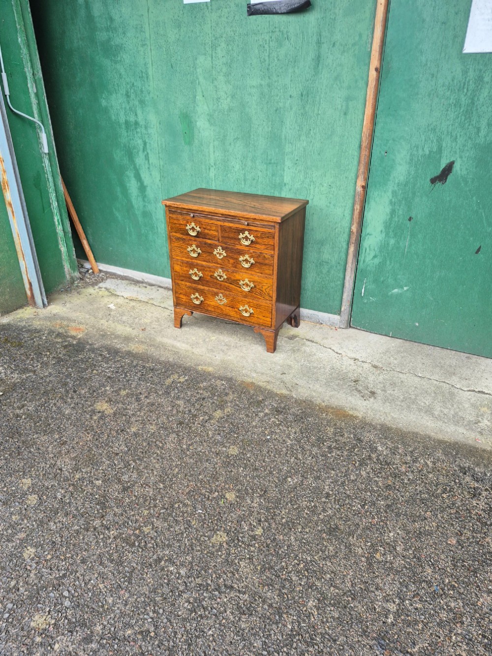 A small rosewood chest of drawers featuring brass handles, bracket feet, and a pull-out brushing slide. View IX