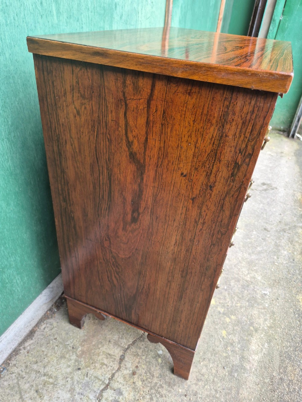 A small rosewood chest of drawers featuring brass handles, bracket feet, and a pull-out brushing slide. View XIII