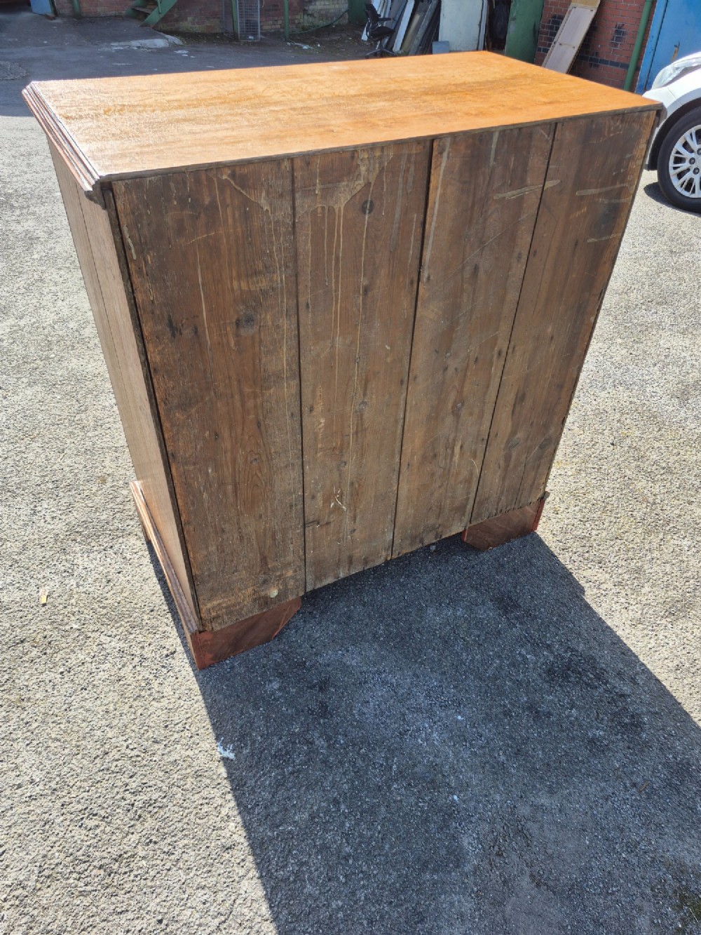 A Georgian golden oak chest of drawers with two short drawers over three long drawers, featuring brass handles and bracket feet. View X