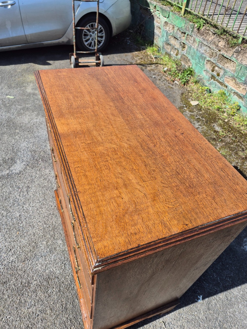 A Georgian golden oak chest of drawers with two short drawers over three long drawers, featuring brass handles and bracket feet. View XI