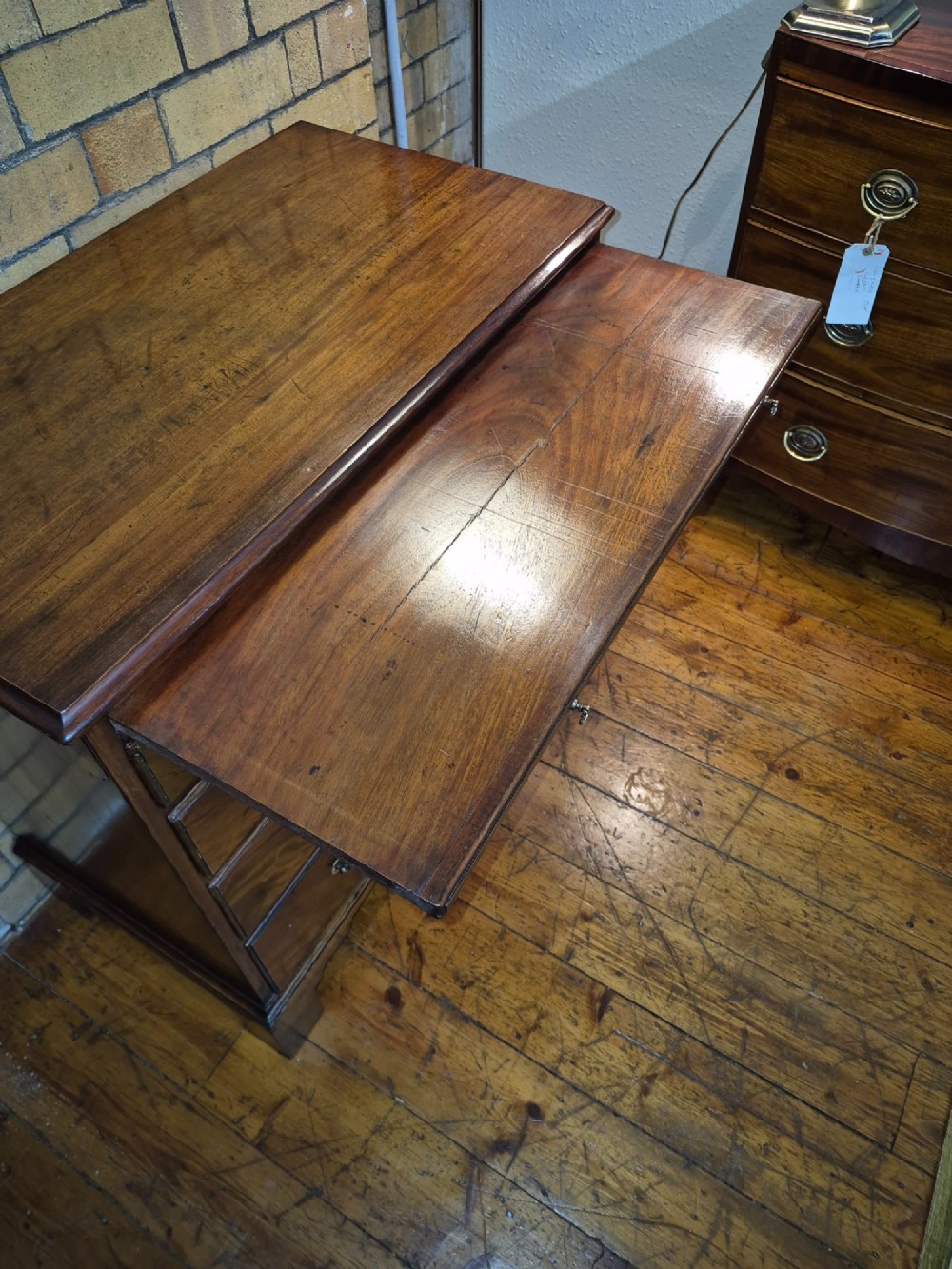 A Georgian mahogany bachelors chest featuring a top brushing slide, four graduated drawers with flame mahogany veneers, brass swan-neck handles, and bracket feet. View IV