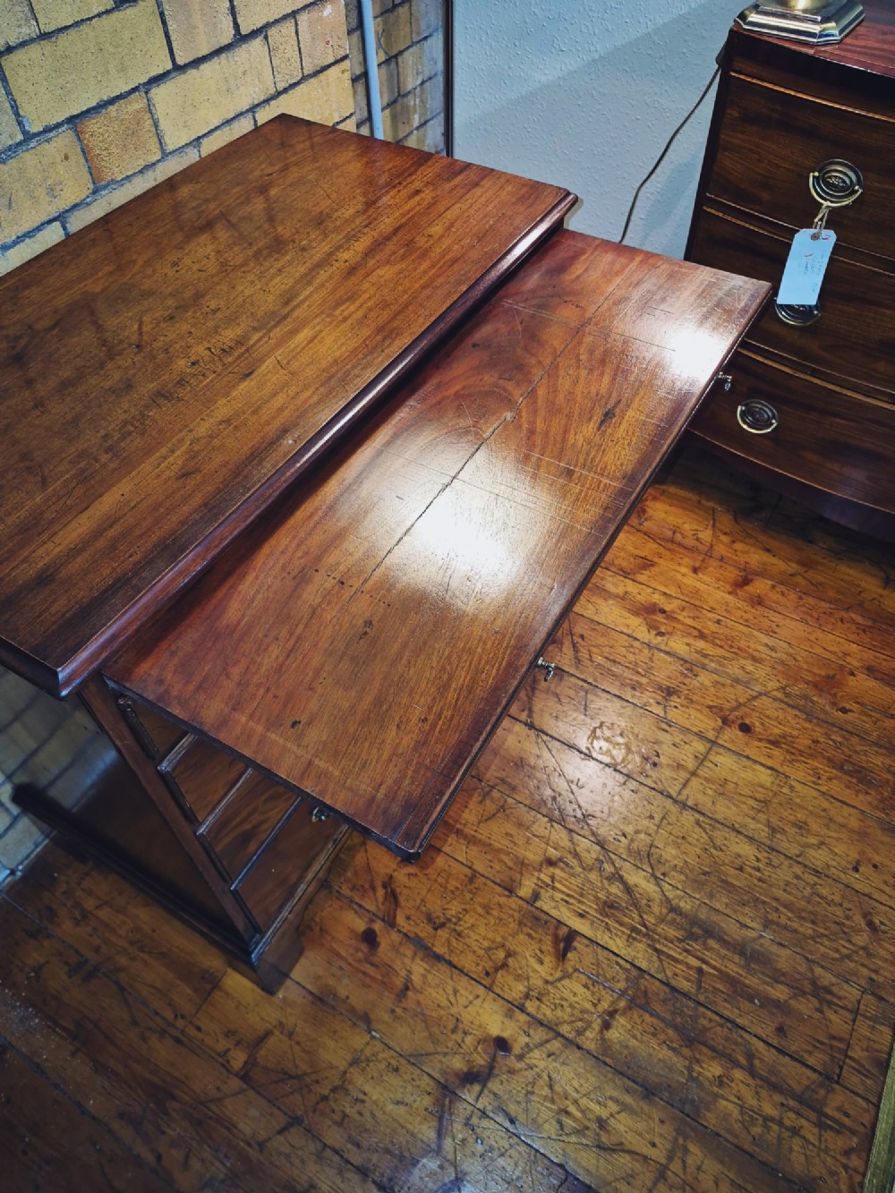 A Georgian mahogany bachelors chest featuring a top brushing slide, four graduated drawers with flame mahogany veneers, brass swan-neck handles, and bracket feet. View VI