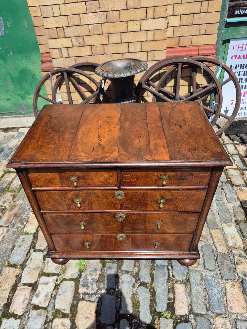 A William and Mary walnut chest of drawers featuring geometric crossbanded drawer fronts, brass drop handles, and compressed bun feet. View VI
