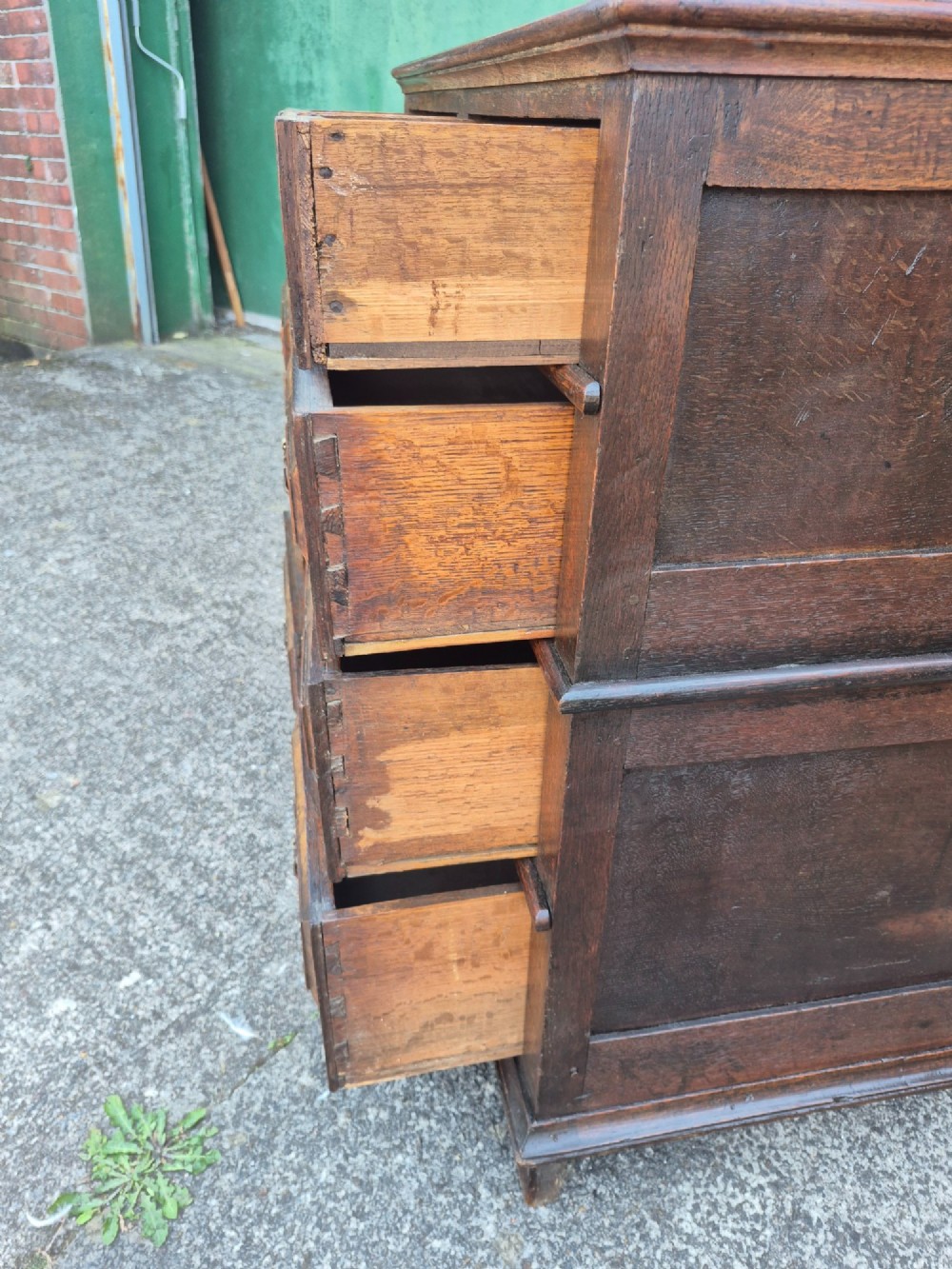 A seventeenth-century Charles II oak and walnut chest of drawers featuring four long drawers with raised geometric panel mouldings and brass drop handles. View VIII