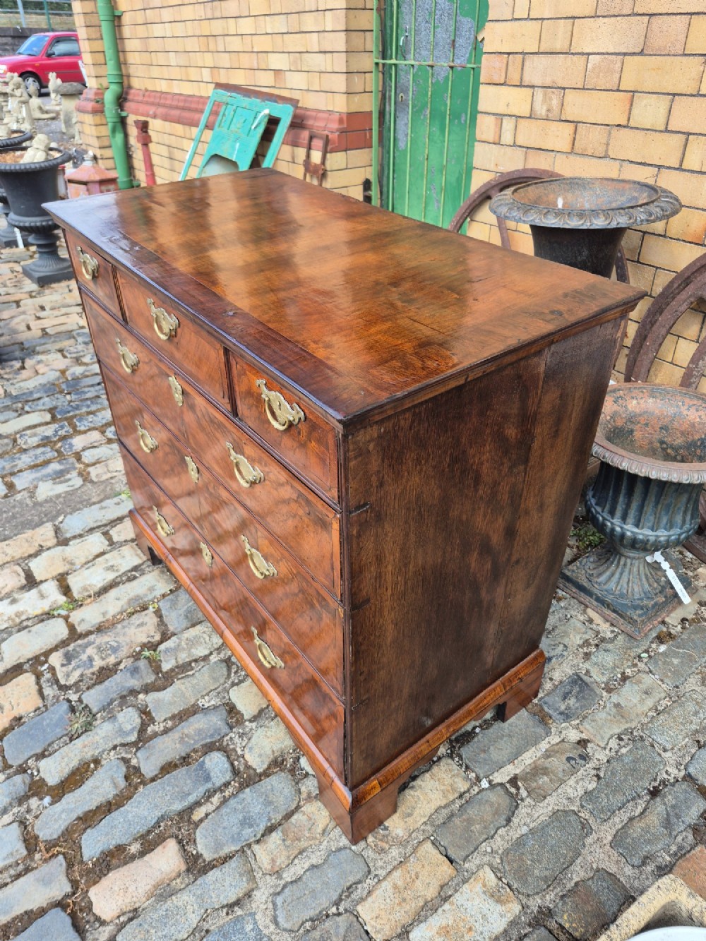 A Georgian walnut and oak chest of drawers featuring three upper small drawers, three full-width lower drawers, brass handles, and bracket feet. View III