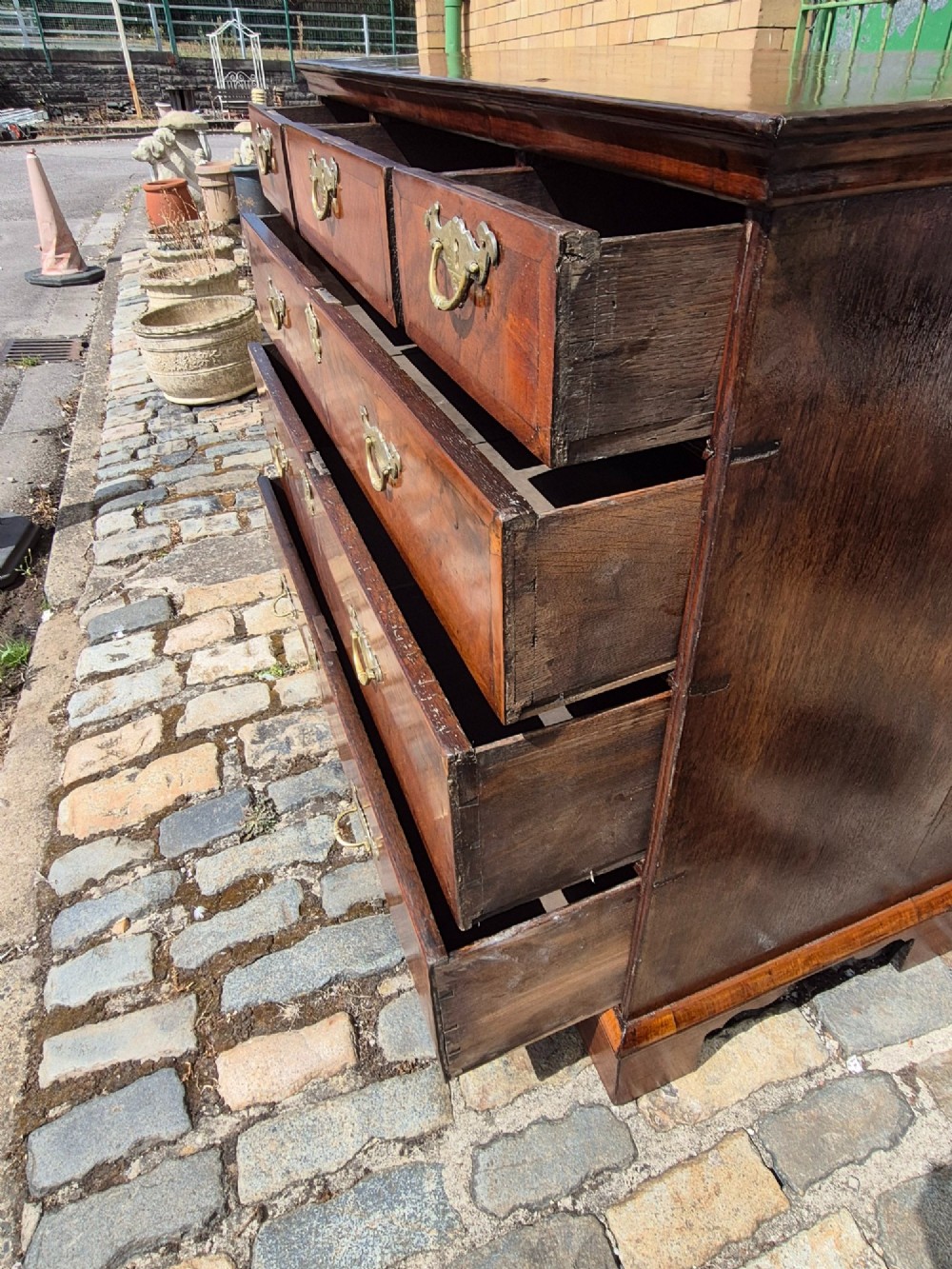 A Georgian walnut and oak chest of drawers featuring three upper small drawers, three full-width lower drawers, brass handles, and bracket feet. View IX