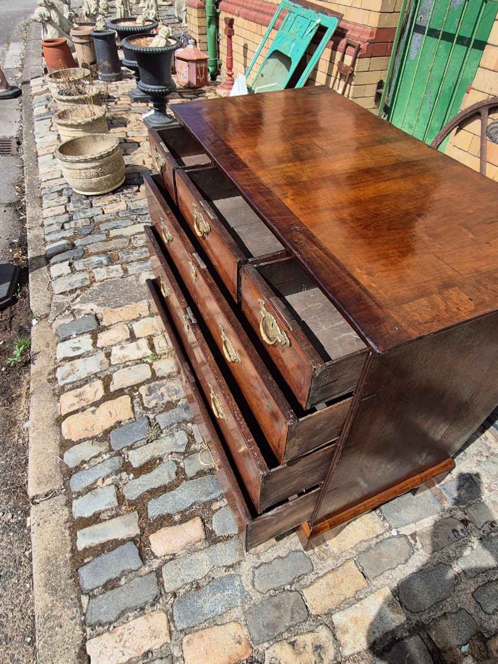 A Georgian walnut and oak chest of drawers featuring three upper small drawers, three full-width lower drawers, brass handles, and bracket feet. View X