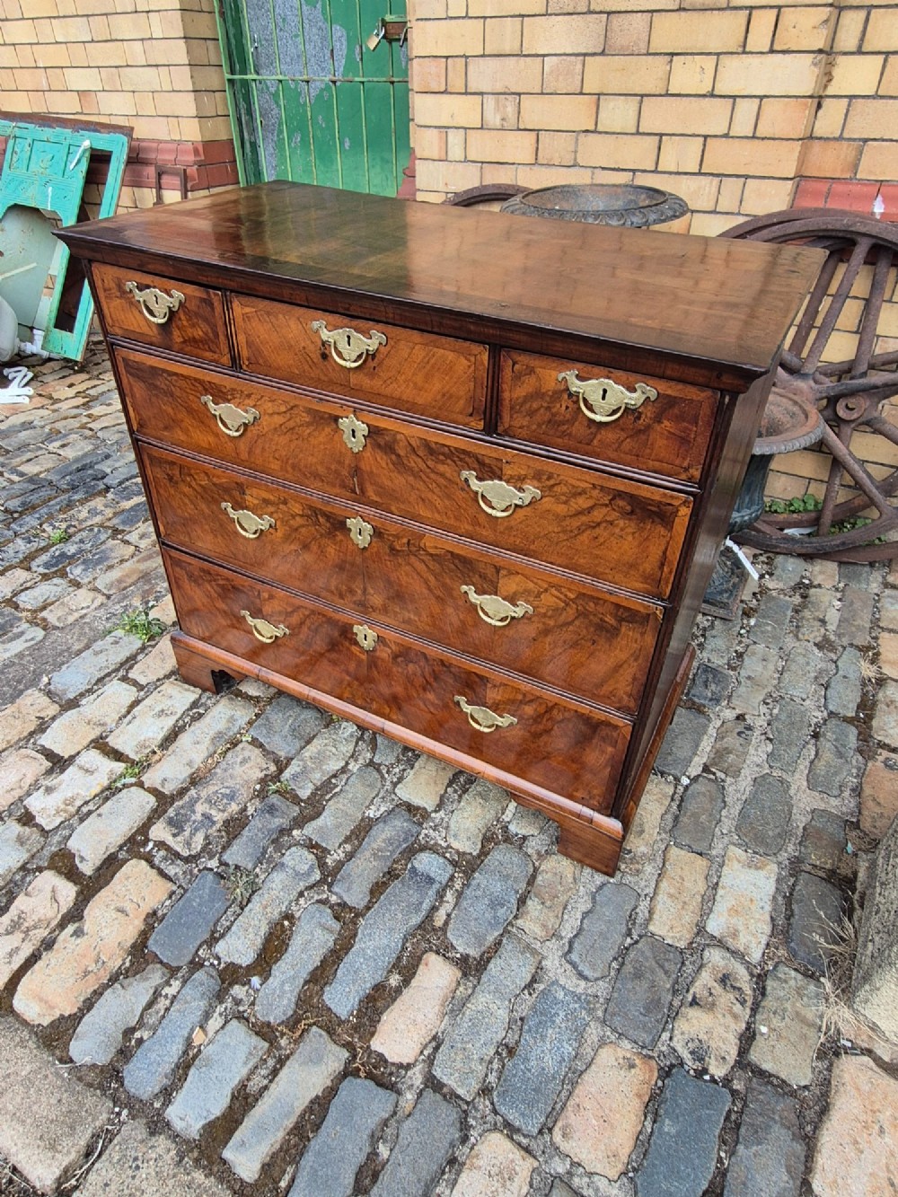 A Georgian walnut and oak chest of drawers featuring three upper small drawers, three full-width lower drawers, brass handles, and bracket feet. View XIII