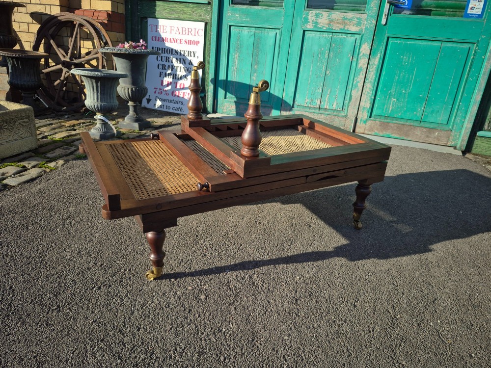 An antique campaign-style daybed crafted from dark timber with three woven cane panels, adjustable reclining sections, turned legs, and brass castors. View XI
