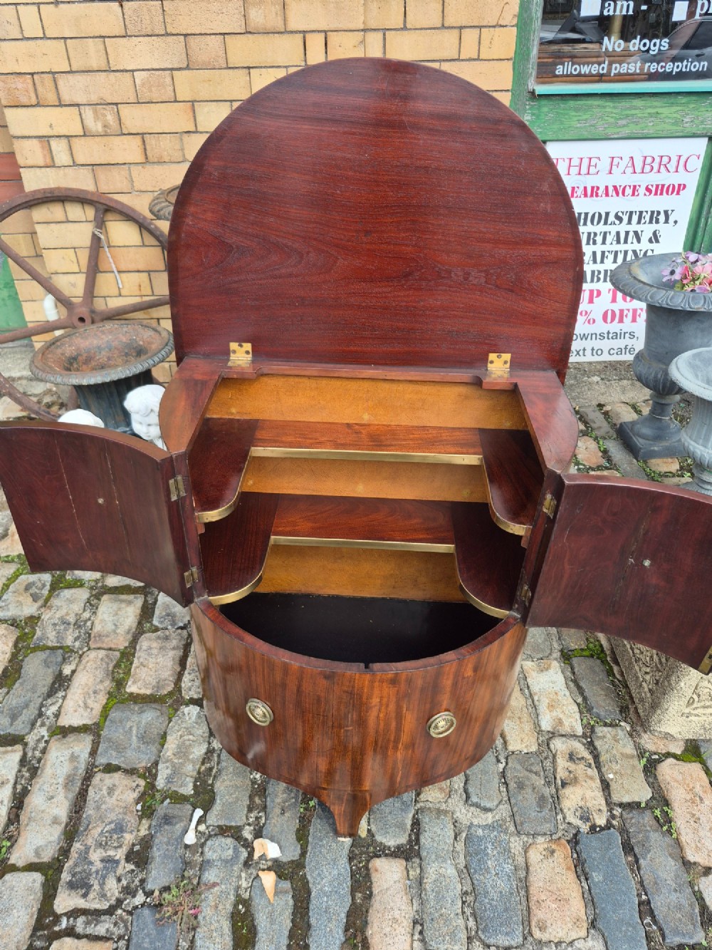 A small semi-circular mahogany cocktail cabinet featuring flame veneer panels and circular brass patera handles. View II