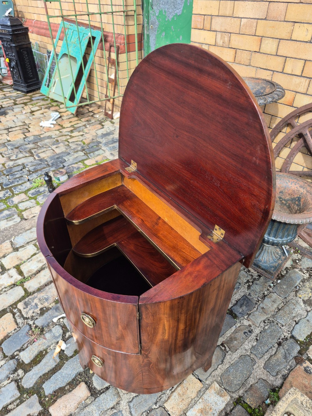 A small semi-circular mahogany cocktail cabinet featuring flame veneer panels and circular brass patera handles. View VII