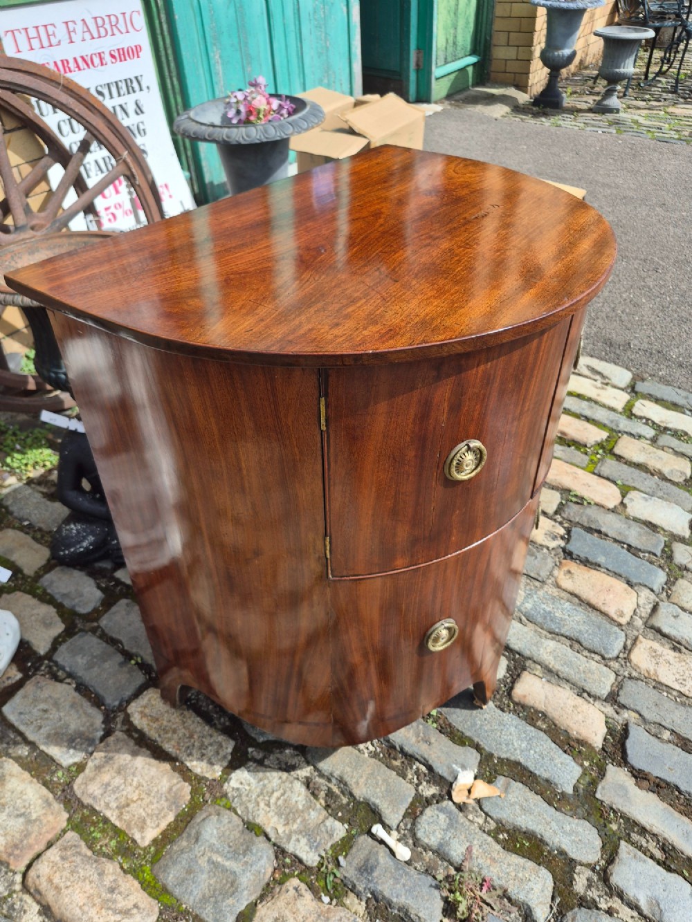 A small semi-circular mahogany cocktail cabinet featuring flame veneer panels and circular brass patera handles. View IX