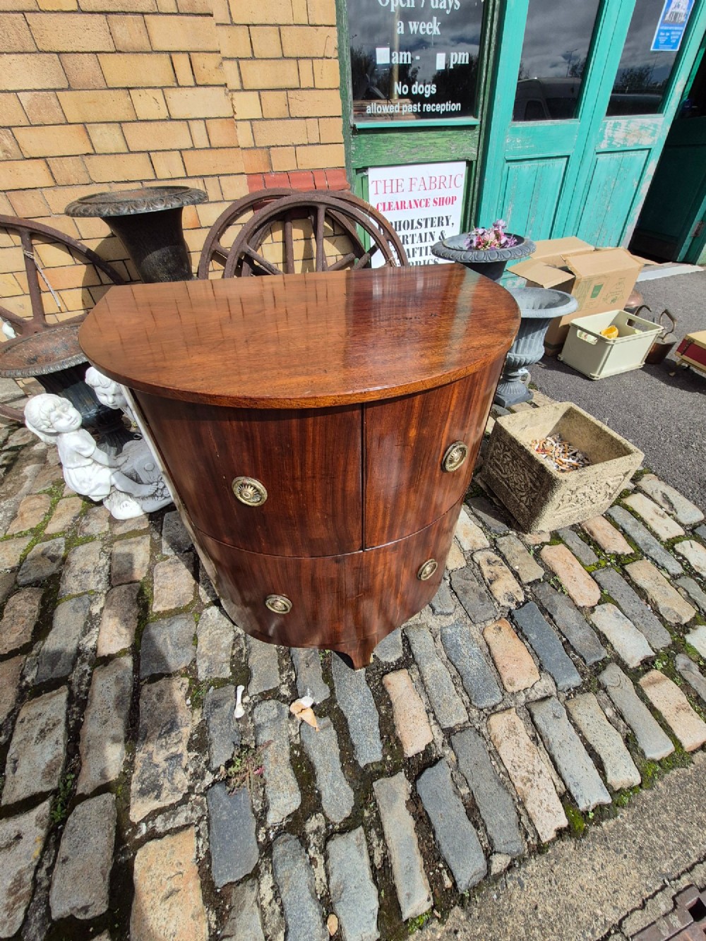 A small semi-circular mahogany cocktail cabinet featuring flame veneer panels and circular brass patera handles. View X