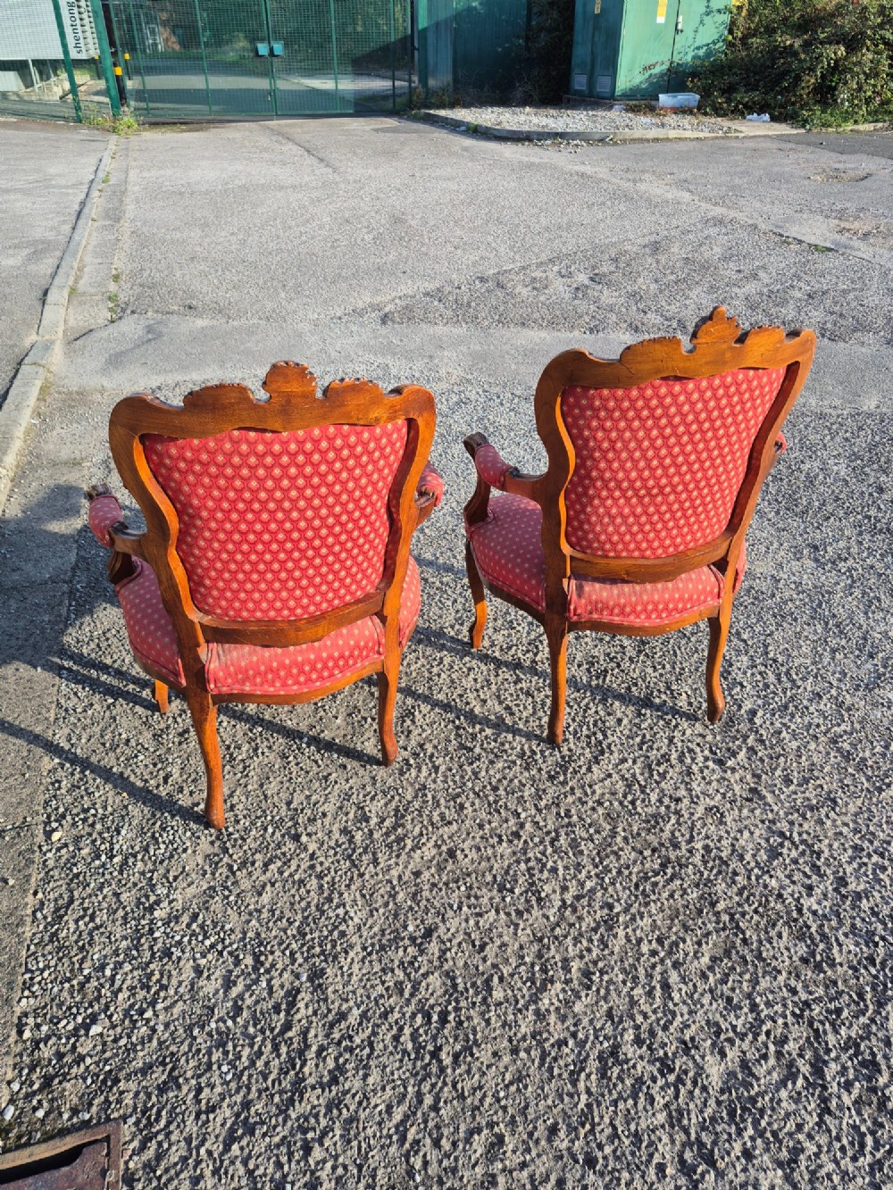 A pair of French carved walnut armchairs upholstered in patterned red fabric with cabriole legs and scrolled cresting. View VII