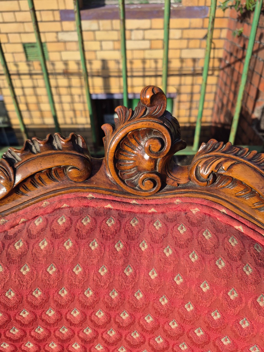 A pair of French carved walnut armchairs upholstered in patterned red fabric with cabriole legs and scrolled cresting. View VIII