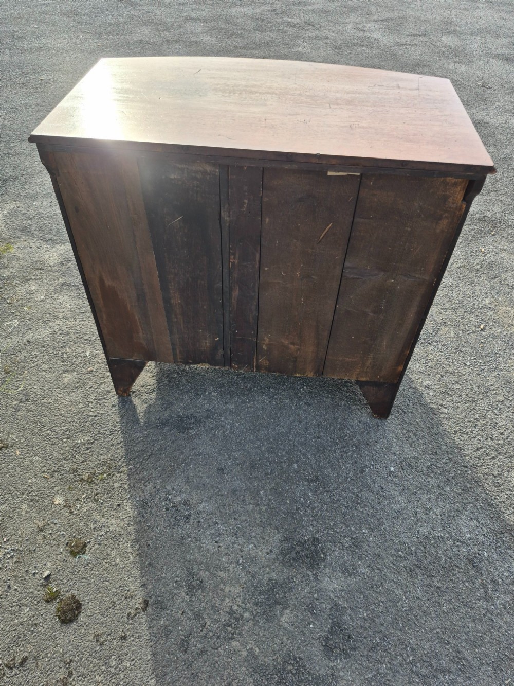 A Regency period bowfront chest of drawers crafted from flame mahogany veneer with three drawers and brass oval handles. View VIII