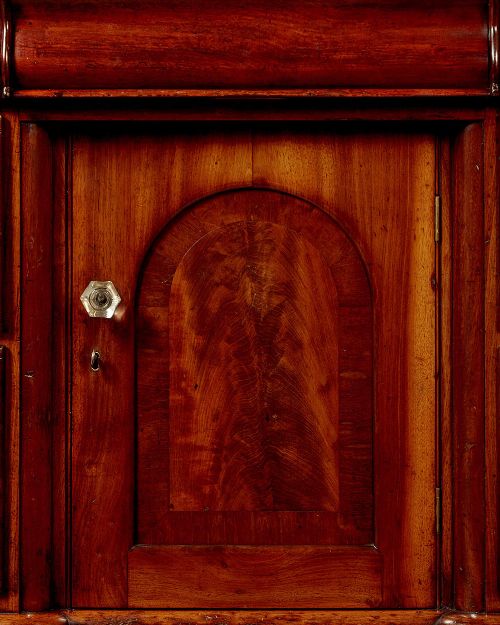 A Victorian walnut sideboard featuring a central arched cupboard door flanked by drawers with faceted glass knobs, set on turned feet. View IX
