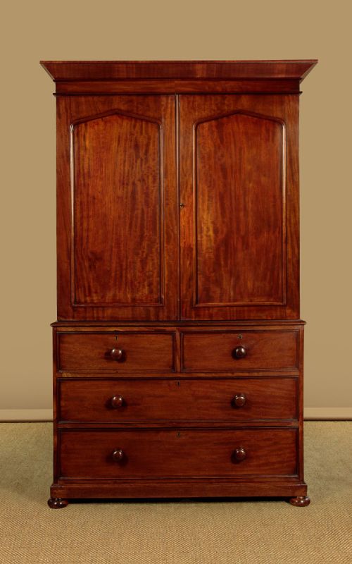 A nineteenth-century mahogany linen press featuring flame mahogany panel doors opening to reveal timber trays above a base of four drawers with turned wooden knobs. View II