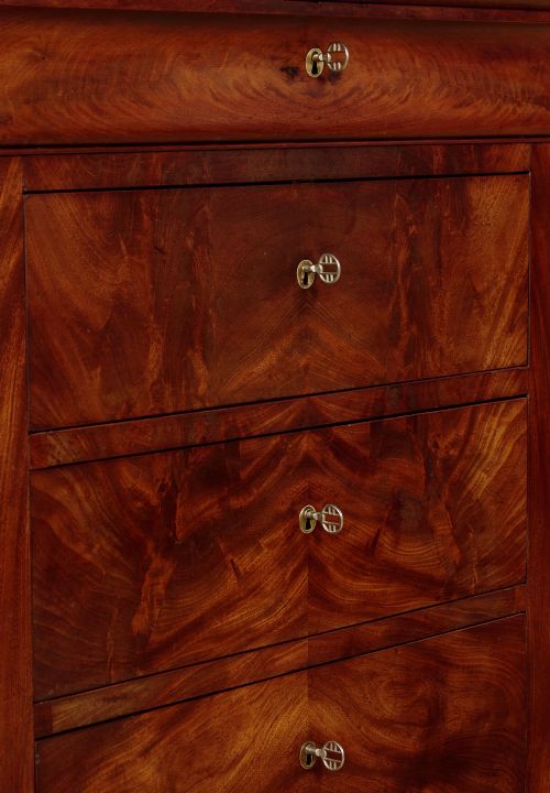 A nineteenth-century flame mahogany commode chest with four drawers, brass escutcheons, a dark slate top surface, and a plinth base. View IX