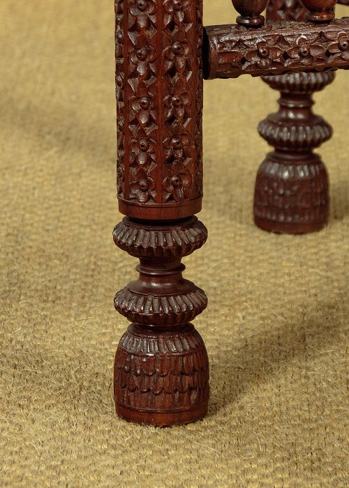 A large round brass tray table featuring detailed floral engravings supported on a dark carved hardwood base with turned legs. View XV