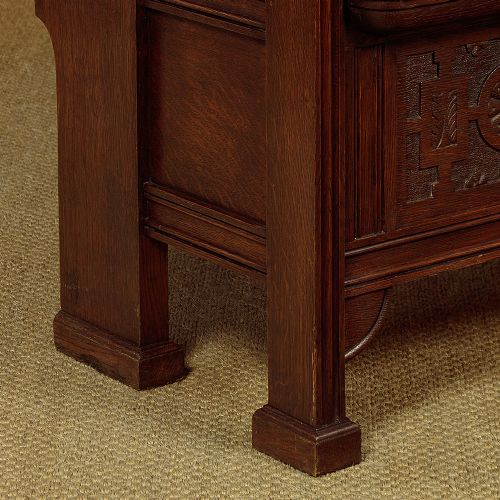 A dark oak canopy box settle featuring intricate carved floral panels, a tall fielded-panel back, and a lift-up storage seat base. View X