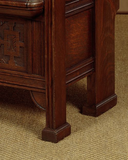 A dark oak canopy box settle featuring intricate carved floral panels, a tall fielded-panel back, and a lift-up storage seat base. View XI